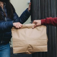 delivery man is delivering a lunch box to a woman - close up view - junk food stock pictures, royalty-free photos & images