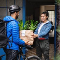 delivery man with bicycle delivering potted plants outdoors in city, coronavirus concept. - food stock pictures, royalty-free photos & images