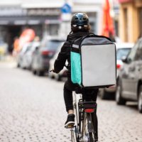 delivery person with thermal box on a bicycle in town - junk food stock pictures, royalty-free photos & images