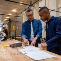 designer explaining to a carpenter his sketch for some furniture - home decoration stockfoto's en -beelden