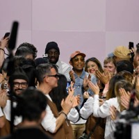 Designer Pharrell Williams celebrates with his design team on the runway during the Louis Vuitton Menswear Fall-Winter 2025/2026 show as part of...