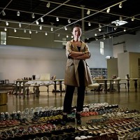 designer standing in showroom surrounded by shoes - fashion stock pictures, royalty-free photos & images