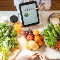 detox concept. afro woman patient of nutritionist drinking lemon water while doctor taking notes, close up - food stock pictures, royalty-free photos & images
