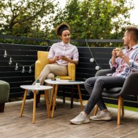 deux amis assis sur le balcon, discutant autour d’une tasse de café - garden decoration photos et images de collection