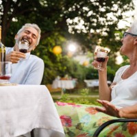 deux amis âgés rient, se lient et dégustent du vin rouge pendant le dîner - garden decoration photos et images de collection