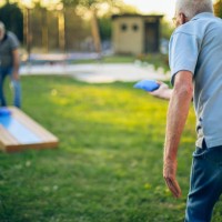 deux vieux amis jouent au trou de maïs dans l’arrière-cour - garden decoration photos et images de collection