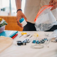 die hand eines mannes verpackt kosmetika und medikamente für die reise in eine tasche mit reißverschluss. - travel stock-fotos und bilder