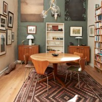 dining table with chairs near bookshelf and frames - home decoration stock-fotos und bilder