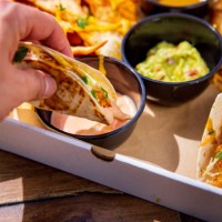 dipping stuffed tortilla in sauce, box with mexican food take out - junk food stock pictures, royalty-free photos & images