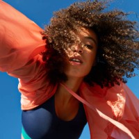 directly below shot of female athlete with curly hair against clear sky - fashion stock pictures, royalty-free photos & images