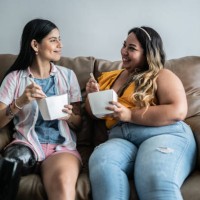 disabled mid adult woman eating yakisoba with her friend in the living room at home - junk food stock pictures, royalty-free photos & images