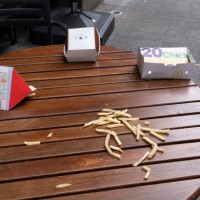 Discarded chips and McDonalds packaging lie on the ground and on a cafe table in central London, on 26th September 2021, in London, England.