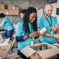 diverse volunteers packing donation boxes in charity food bank - food stock pictures, royalty-free photos & images
