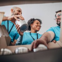 diverse volunteers packing donation boxes with canned food in food bank - food stock pictures, royalty-free photos & images