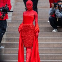 Doja Cat wears red off shoulder dress, red boots outside Schiaparelli during Paris Fashion Week - Haute Couture Spring Summer : Day One on January...