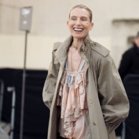 Dree Hemingway wears light peach colour mini shorts and top, long beige trench coat, and white bag outside the Chloe fashion show during the...
