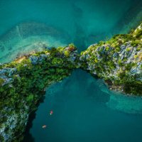 drone view on rocks and canoes floating on turquoise water in the halong bay, vietnam - travel stock pictures, royalty-free photos & images