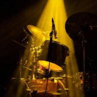 drum set on stage under a yellow light - concert stock pictures, royalty-free photos & images