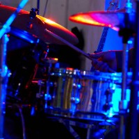 drummer is playing drums in a dimly lit background during a rock concert. - concert stock pictures, royalty-free photos & images