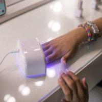 drying nails under uv lamp during manicure. - nails art stock pictures, royalty-free photos & images