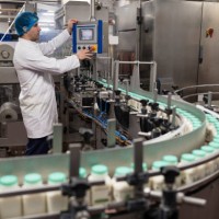 early 30s male worker operating computer in milk factory - food stock pictures, royalty-free photos & images