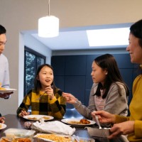 east asian parents and offspring enjoying takeout for dinner - junk food stock pictures, royalty-free photos & images