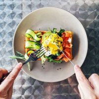 eating brunch with waffle, avocado, cucumber, salmon and poached egg, personal perspective - food stock pictures, royalty-free photos & images