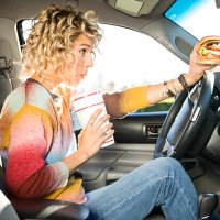 eating fast food hamburgers and driving. - junk food stock pictures, royalty-free photos & images