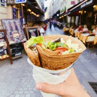 eating french crepe pancake with cheese and fresh vegetables on the street, personal perspective - junk food stock pictures, royalty-free photos & images