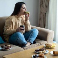 eating sugary food on sofa - food stock pictures, royalty-free photos & images