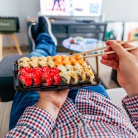eating sushi delivery at home while laying on the couch, personal perspective view - junk food stock pictures, royalty-free photos & images