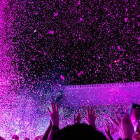 ecstatic people with energy dancing in a vibrant live music concert with pink confetti and crowd with hands up - concert stock pictures, royalty-free photos & images