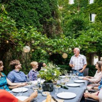 elderly man addressing his family during outdoor meal - garden decoration stock pictures, royalty-free photos & images