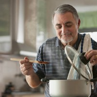 elderly man cooking - food stockfoto's en -beelden