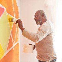 elderly man painting design on wall at home - home decoration stock pictures, royalty-free photos & images