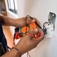 electrician fixing an electrical outlet and measuring the voltage - home decoration stock pictures, royalty-free photos & images