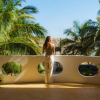 elegant woman on the balcony at sunset looking at palm trees on tourist resort - travel stock pictures, royalty-free photos & images