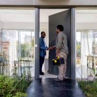 elektriker, der für einen service in ein haus kommt und den besitzer begrüßt - home decoration stock-fotos und bilder