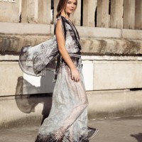 Ellie Thumann wears grey and black pattern sheer dress, sunglasses and black clutch outside the Elie Saab fashion show during the Womenswear...
