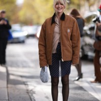 Emili Sindlev is seen wearing a beige cardigan, with a brown jacket from Carhartt, dark blue shorts with white dots, a gray Miu Miu Hobo handbag,...