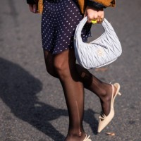 Emili Sindlev wears a beige top and cardigan, blue polka dot mini skirt, brown Carhartt jacket, gret Miu Miu bag and beige kitten heels, outside Miu...