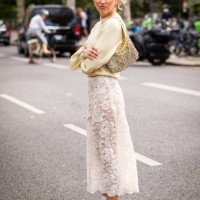 Emili Sindlev wears a yellow sweater, cream lace midi skirt, silver sneakers and yellow bag with silver metal details, outside Rabanne, during the...