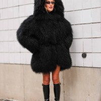Emili Sindlev wears black faux fur shearling hooded Michael Kors mongolian coat, shiny black knee high heeled boots leather shoes, outside Michael...