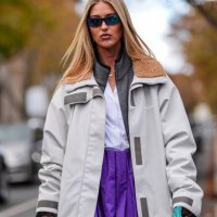 Emili Sindlev wears dark blue sunglasses, dark gray Miu Miu oversized unzipped sweater, white t-shirt, dark purple over the knee graphic white black...