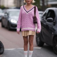 Emilia Silberg is seen wearing a Lacoste pink sweater, Lacoste tan beige skirt and maroon bag outside Lacoste Show during the Womenswear Fall/Winter...