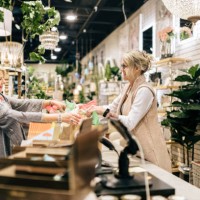 employee rings up customer for her purchase - home decoration stockfoto's en -beelden