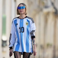 Emy Venturini wears sunglasses from Pierre Cardin, a blue and white striped Argentina soccer t-shirt from Adidas with printed 