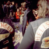 English singer, songwriter, actor, and film producer Mick Jagger of the English rock band The Rolling Stones performs as Hell's Angels guard the...