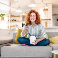 enjoying at home eating takeaway meal and watching tv - junk food stock pictures, royalty-free photos & images