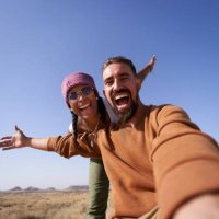 enthusiastic photo of nomadic couple taking a selfie showing the desert to post it on social media apps. - travel photos et images de collection